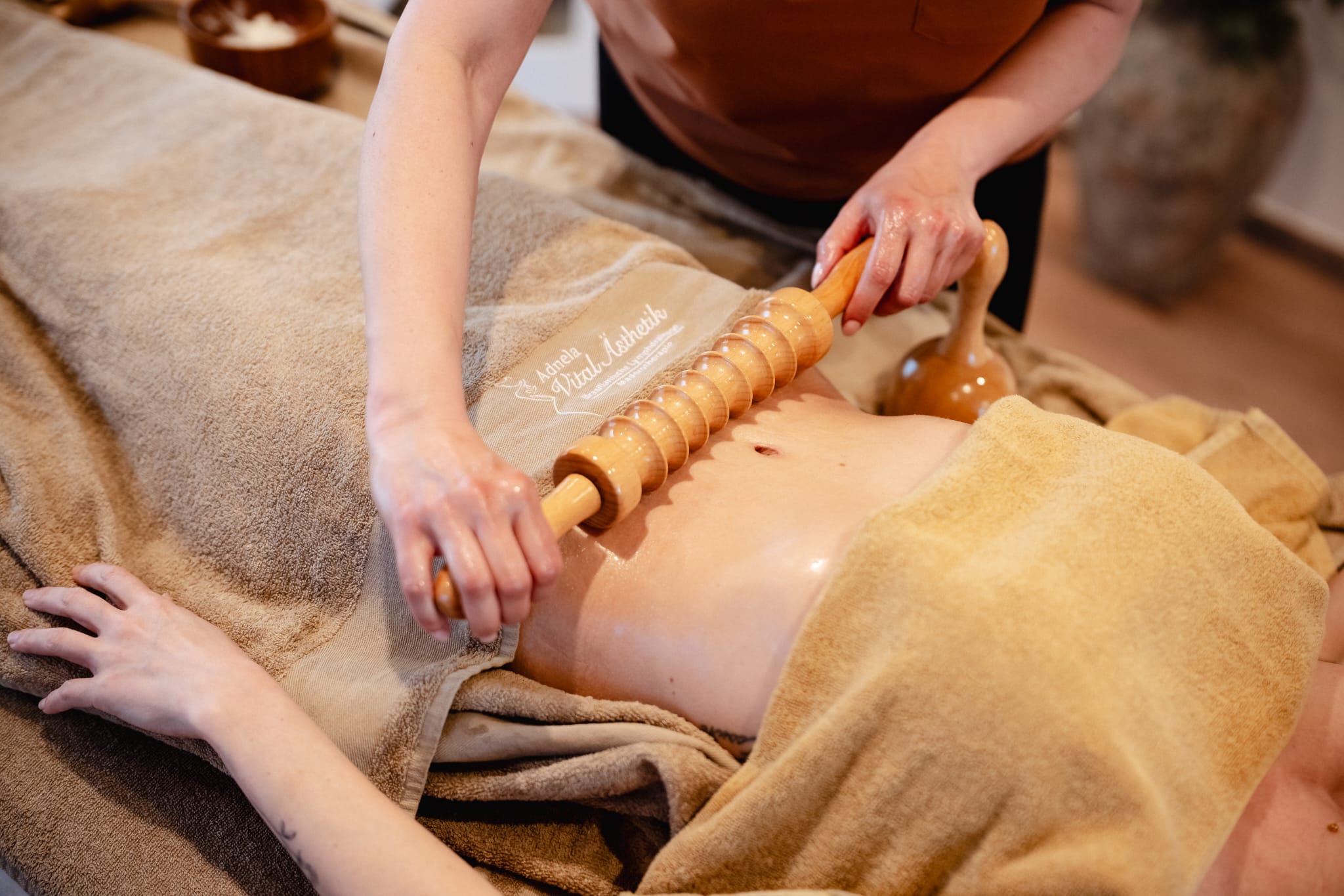 Maderotherapie am Bauch mit der Madero-Holzrolle im Studio Adnela Vital Ästhetik