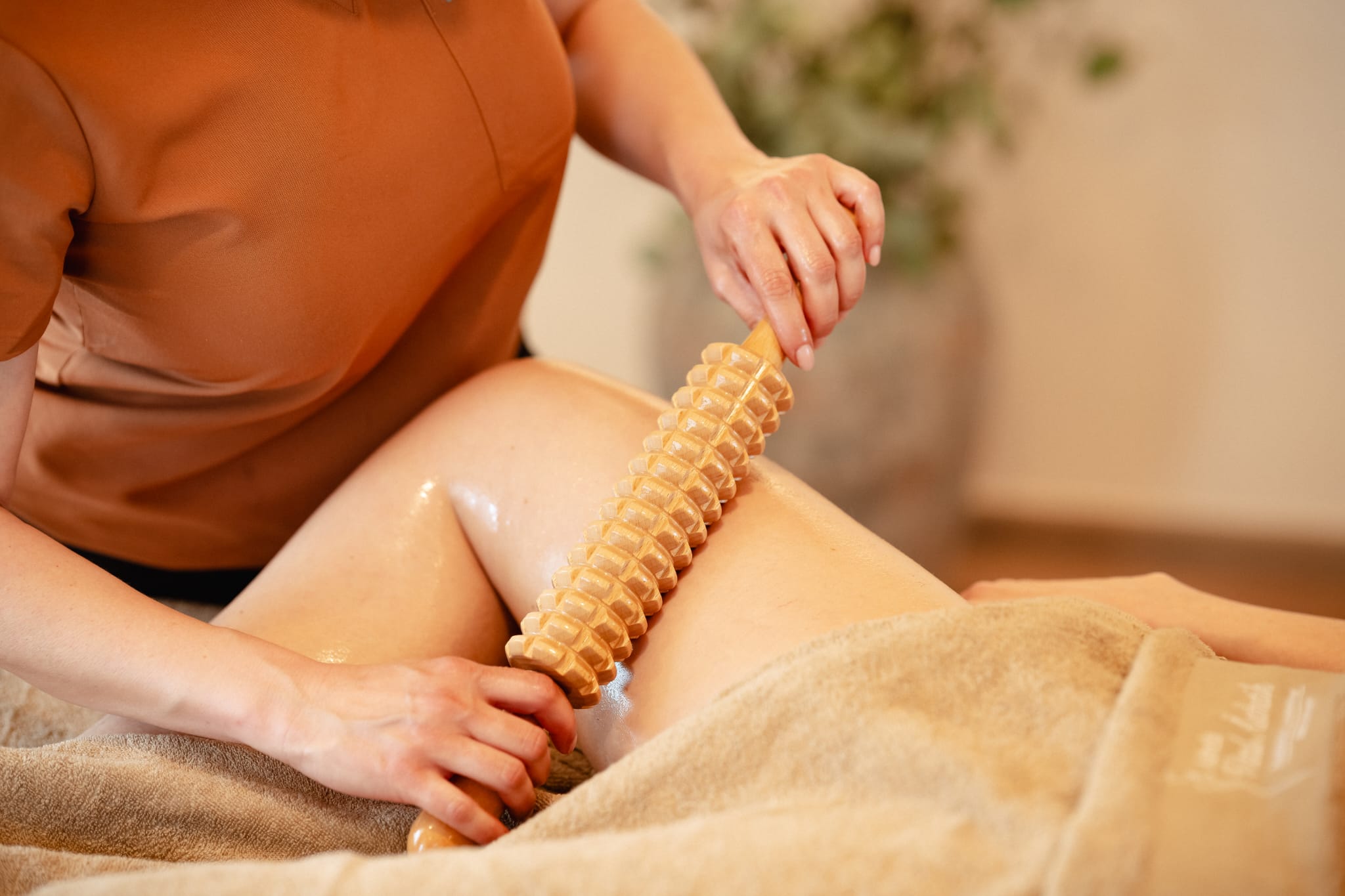 Maderotherapie am Oberschenkel mit geriffelter Madero-Holzrolle